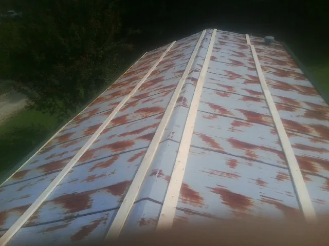 Rusted metal roof panels with new wood purlins before replacement — Storm Damage Roof Repair in Camden Wyoming by Roofing Brothers