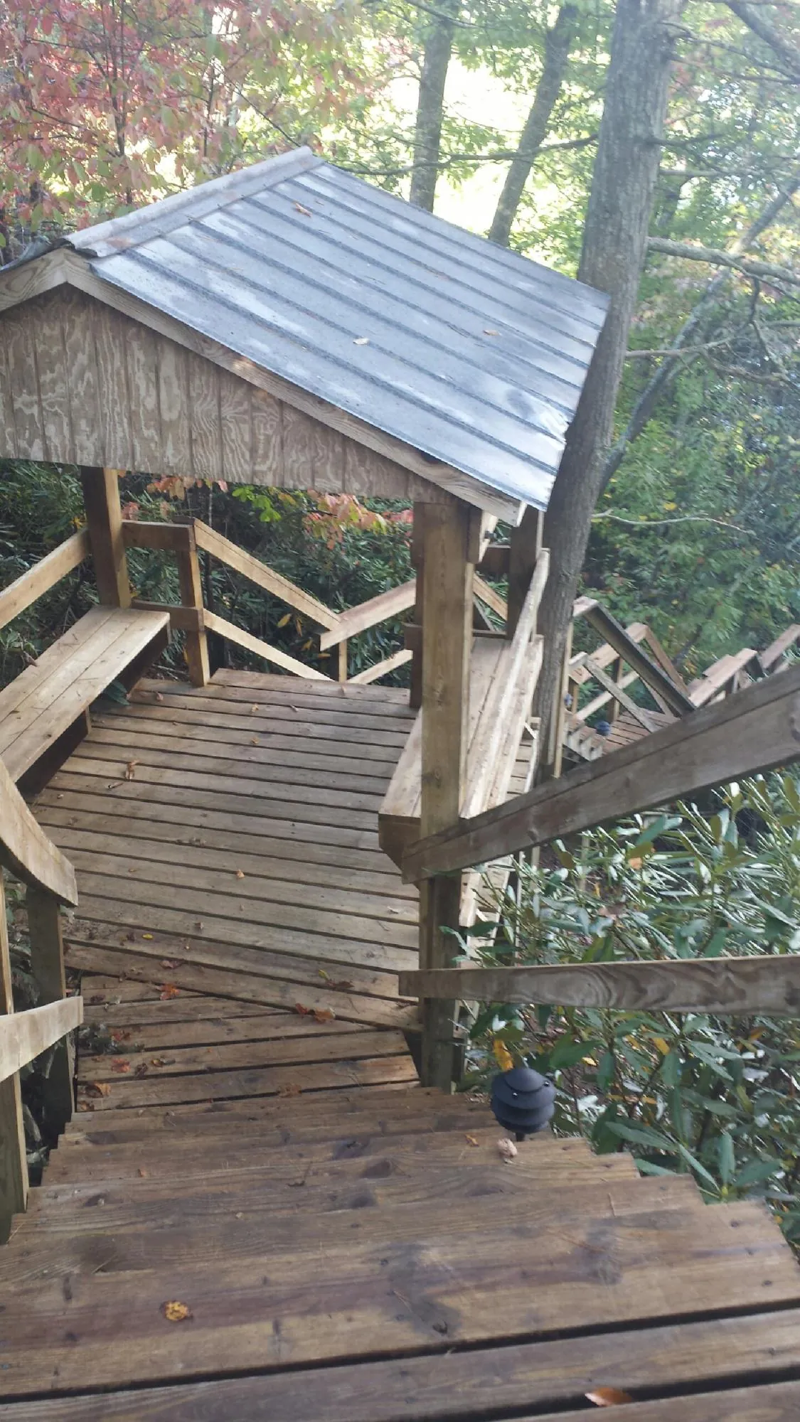 Metal roofed shelter over wooden steps on a wooded walkway — Skylight Repair & Installation work by our crew in Camden Wyoming