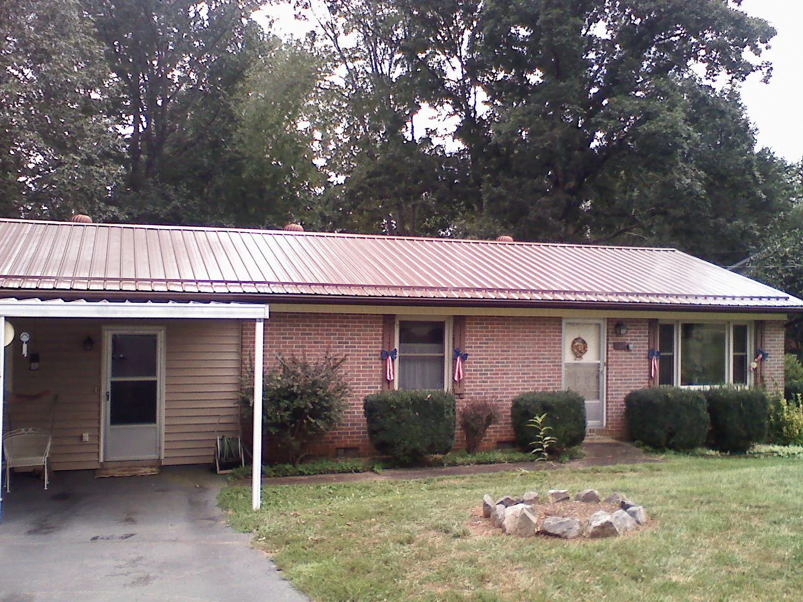 Bronze metal roof and carport on a brick ranch home — Roof Repair work by our crew in Camden Wyoming